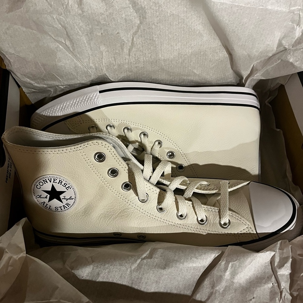 NEVER WORN. White leather Chuck Taylors.